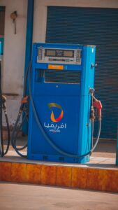 Hand holding a fuel pump nozzle at a petrol station