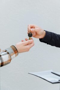 Person handing over car keys to another person